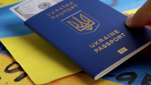 Hand Menempatkan Paspor Biometrik Ukraina Dengan Kas Latar Belakang Bendera — Stok Video