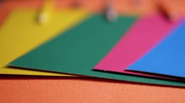 Turuncu Masa Arkaplanı üzerine serilmiş çok renkli karton kağıtlar. Okul malzemeleri, kalemler, renkli kağıtlar. Renkler ve şekiller üzerine çalışma. Gökkuşağı, spektrum. Çocukları okula hazırlamak.