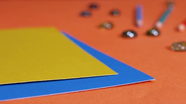 Женщины Кладут Разноцветные Листы Картона Оранжевый Фон Подготовка Цветной Бумаги — стоковое видео