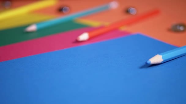 Многоцветные Листы Картонной Бумаги Выложенные Фоне Оранжевого Стола Школьные Принадлежности — стоковое видео