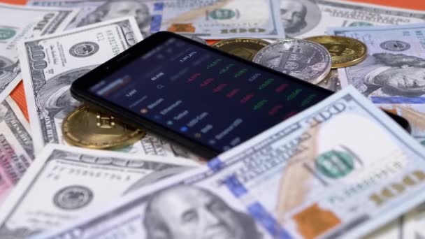 在Smartphone上显示股票市场的红色报价 时间流逝 网上交易 密码货币对 证券交易所 改变价格 100美元的钞票 比特币放在桌上 买了密码 — 图库视频影像