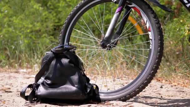 Sports Bike Standing Forest Sand Backpack Sunglasses Close Front Wheel — Vídeo de Stock