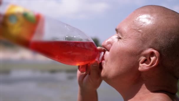 Bald Wrinkly Man Greedily Drinks Juice Drink Colored Water Sky — Stockvideo