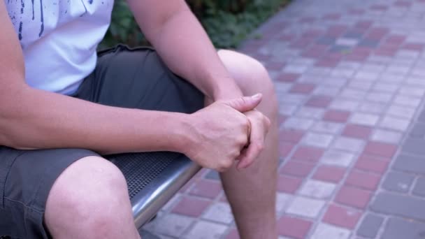 Male Rubbing Hands Sitting Bench Urban Park Moment Waiting Excitement — Vídeo de stock