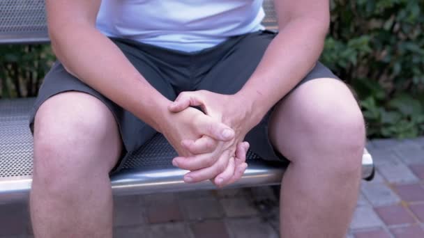 Male Rubbing Hands Sitting Bench Urban Park Moment Waiting Excitement — Vídeos de Stock