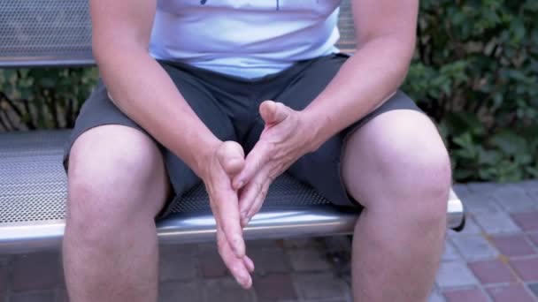 Male Rubbing Hands Sitting Bench Urban Park Moment Waiting Excitement — Vídeo de Stock