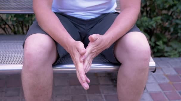 Male Rubbing Hands Sitting Bench Urban Park Moment Waiting Excitement — Stock Video
