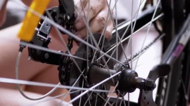 Close-up Rotation of a Bicycle Wheel, Pedals, Chain. Six-speed gearbox. Master checks transport before the trip. Movement of gear on a chain. Bicycle repair at home. Test, restoration, mending.