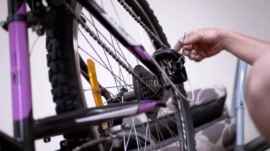 Close-up Rotation of a Bicycle Wheel, Pedals, Chain. Six-speed gearbox. Master checks transport before the trip. Movement of gear on a chain. Bicycle repair at home. Test, restoration, mending.