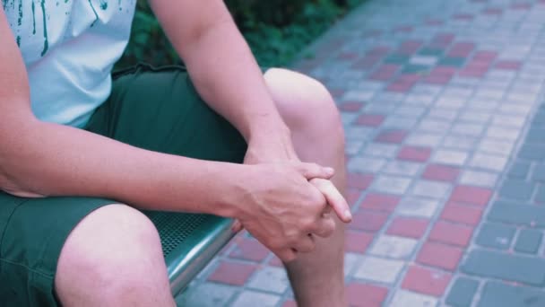 Male Rubbing Hands Sitting Bench Urban Park Moment Waiting Excitement — Wideo stockowe