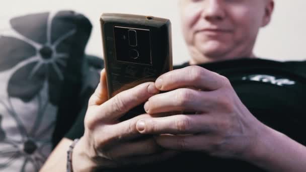Χαλαρωμένος Άνδρας Χαλαρώνοντας Έναν Καναπέ Βλέποντας Βίντεο Μια Οθόνη Smartphone — Αρχείο Βίντεο