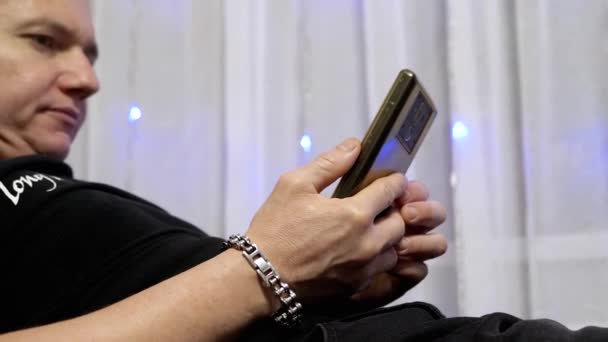 Rahatlamış Erkek Koltukta Rahatlıyor Evde Akıllı Telefon Ekranında Video Zliyor — Stok video
