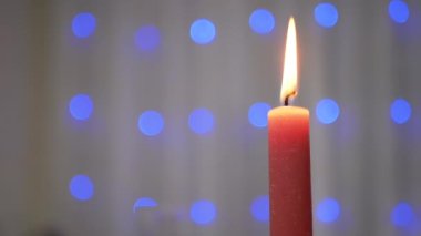 Bulanık Arkaplanda Yanan Noel Kırmızı Mum Parıldayan Çelengi. Bir çelengin üzerindeki parlak mavi, bulanık noel ışıkları. Soyut arkaplan. Parlak ışıklar. Yeni yıl arifesi. Xmas.