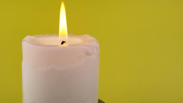 在孤立的黄色背景上以明亮的火焰燃烧白色蜡烛 明亮的黄色平静的火 记忆的概念 摘要背景 慢动作 后续行动 — 图库视频影像