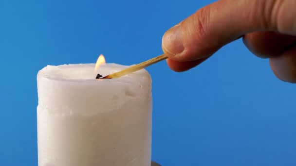 Свечи Белого Воска Помощью Спички Синем Фоне Яркое Пламя Огонь — стоковое видео