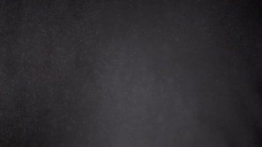 Karışık Toz Parçacıkları Girdabı, Un, Enkaz, Kara Arkaplanda Uçan. Beyaz tozun dinamik parçacıkları, kar, pul, duman rastgele döner, döner, döner, yüzer, sis içinde havada süzülür..