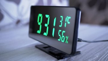 Yeşil Ekrandaki Dijital Saat 9: 31, Sıcaklık, Hava Nemi. Modern ayna saati, termometresi olan çalar saat, beyaz arka plandaki masada duran hidrometre. Zaman kavramı.