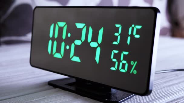 緑のディスプレイ上のデジタル時計表示時間10 空気湿度 現代のミラークロック 温度計付き目覚まし時計 白い背景に机の上に立って水分計 時間概念 — ストック動画