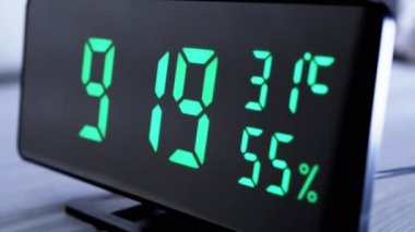 Yeşil Ekrandaki Dijital Saat 9: 19, Sıcaklık, Hava Nemi. Modern ayna saati, termometresi olan çalar saat, beyaz arka plandaki masada duran hidrometre. Zaman kavramı.