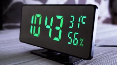 Yeşil Ekrandaki Dijital Saat 10: 43, Sıcaklık, Hava Nemi. Modern ayna saati, termometresi olan çalar saat, beyaz arka plandaki masada duran hidrometre. Zaman kavramı.