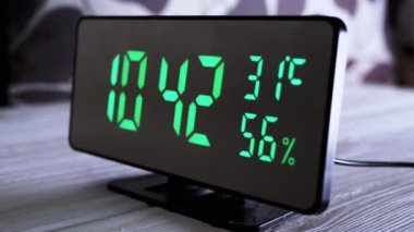 Yeşil Ekrandaki Dijital Saat 10: 42, Sıcaklık, Hava Nemi. Modern ayna saati, termometresi olan çalar saat, beyaz arka plandaki masada duran hidrometre. Zaman kavramı.