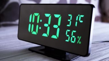 Yeşil Ekrandaki Dijital Saat 10: 33, Sıcaklık, Hava Nemi. Modern ayna saati, termometresi olan çalar saat, beyaz arka plandaki masada duran hidrometre. Zaman kavramı.