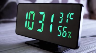 Yeşil Ekrandaki Dijital Saat Saat 10: 31, Sıcaklık, Hava Nemi. Modern ayna saati, termometresi olan çalar saat, beyaz arka plandaki masada duran hidrometre. Zaman kavramı.
