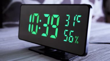 Yeşil Ekran 'daki dijital saat 10: 39' u gösteriyor. Hava sıcaklığı, nem oranı. Modern ayna saati, termometresi olan çalar saat, beyaz arka plandaki masada duran hidrometre. Zaman kavramı.