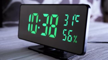 Yeşil Ekrandaki Dijital Saat 10: 38, Sıcaklık, Hava Nemi. Modern ayna saati, termometresi olan çalar saat, beyaz arka plandaki masada duran hidrometre. Zaman kavramı.