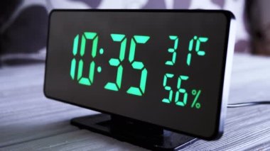 Yeşil Ekran 'da dijital saat 10: 35' i gösteriyor. Hava sıcaklığı, nem oranı. Modern ayna saati, termometresi olan çalar saat, beyaz arka plandaki masada duran hidrometre. Zaman kavramı.