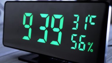 Yeşil Ekrandaki Dijital Saat 9: 39, Sıcaklık, Hava Nemi. Modern ayna saati, termometresi olan çalar saat, beyaz arka plandaki masada duran hidrometre. Zaman kavramı.