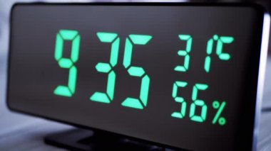Saat 9: 35 'te, saat 9: 35' i gösteriyor. Hava sıcaklığı, nem oranı. Modern ayna saati, termometresi olan çalar saat, beyaz arka plandaki masada duran hidrometre. Zaman kavramı.