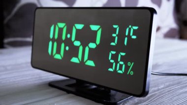 Yeşil Ekrandaki Dijital Saat Saat 10: 52, Sıcaklık, Hava Nemi. Modern ayna saati, termometresi olan çalar saat, beyaz arka plandaki masada duran hidrometre. Zaman kavramı.