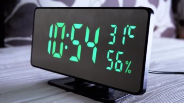 Yeşil Ekrandaki Dijital Saat Saat 10: 54, Hava Sıcaklığı, Hava Nemi. Modern ayna saati, termometresi olan çalar saat, beyaz arka plandaki masada duran hidrometre. Zaman kavramı.