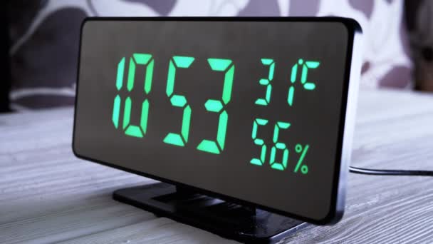 緑のディスプレイ上のデジタル時計表示時間10 現代のミラークロック 温度計付き目覚まし時計 白い背景に机の上に立って水分計 時間概念 — ストック動画