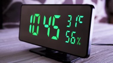 Yeşil Ekran 'da dijital saat 10: 45' i gösteriyor. Sıcaklık, nem. Modern ayna saati, termometresi olan çalar saat, beyaz arka plandaki masada duran hidrometre. Zaman kavramı.