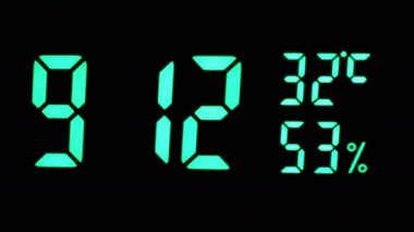 Yeşil Ekran 'daki dijital saat 9: 12' yi gösteriyor. Hava sıcaklığı, nem oranı. Modern elektronik saat, termometresi olan çalar saat, siyah arka planda hidrometre. Zaman kavramı. Günaydın..