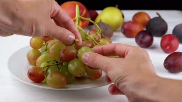 Женские Руки Отрывают Ягоды Гроздья Винограда Лежащего Тарелке Столе Сочный — стоковое видео