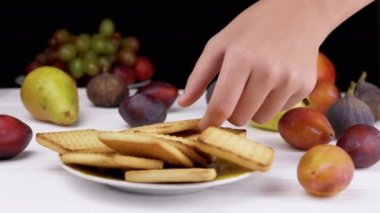 Anne El, Childs Palm 'a Tatlı Kurabiye yerine sağlıklı bir elma koydu. El annesi el çocuğuna asılıyor. Bir çocuk eli, zararlı krakerlere uzanıyor. Meyve. Sağlıklı gıda ve abur cubur konsepti.