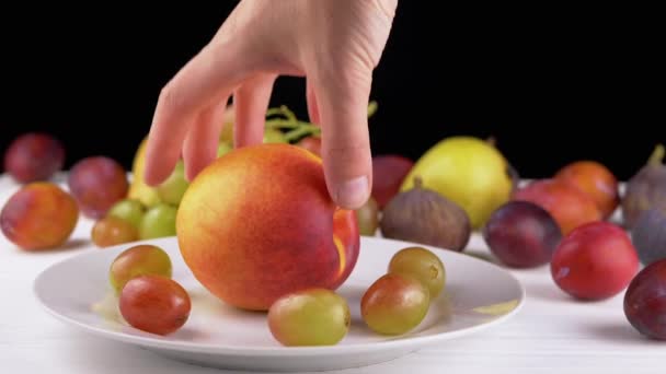 Weibliche Hand Nimmt Einen Reifen Apfel Oder Pfirsich Auf Einem — Stockvideo