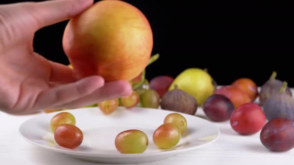 Main Féminine Mettre Une Pomme Mûre Pêche Sur Une Assiette — Video