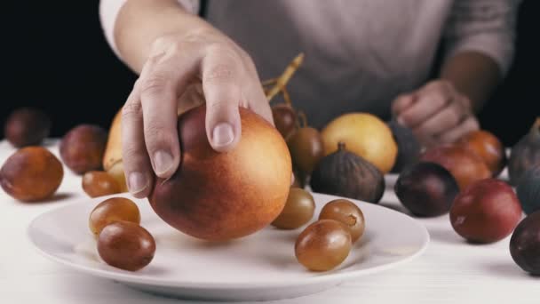 Weibliche Hand Nimmt Einen Reifen Apfel Von Einem Teller Beißt — Stockvideo