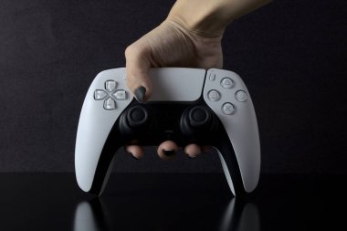 Brezilya, SP - Ekim 06, 2021: New Sony PlayStation 5 Denetleyicili Kadın eli siyah arkaplanda izole edildi. Çift Duygu