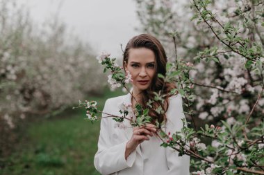 Bahar bahçesinde çiçeklerle poz veren muhteşem bir model. 