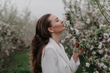 Bahar bahçesinde çiçeklerle poz veren muhteşem bir model. 