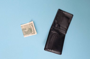 Cüzdan ve iki dolar mavi arka planda yatıyor. İflas etti. Para sıkıntısı var. Birikimlerin önemi. Mali yardım kavramı.