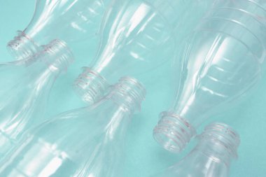 Turkuaz arka planda boş plastik şişeler. Plastik geri dönüşüm sorunu. Plastik üretim ve işleme kavramı.