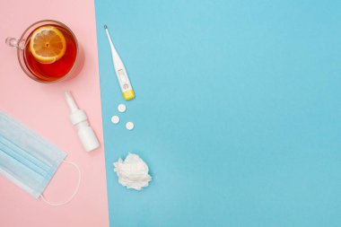 Üşütürsün. Grip mevsimi. Hastalık. Düz yatıyordu. Tıbbi maske, haplar, burun spreyi kullanılmış mendil, termometre ve limon çayı. Mesajın için yer aç. Uzayı kopyala Modelleme. Mevsimlik soğuk kavram. 