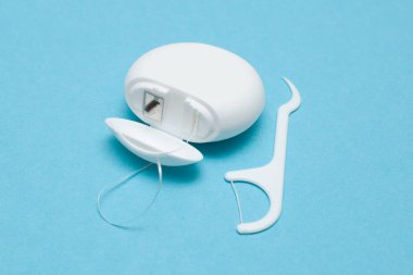 Mavi arka planda diş ipi. Diş sağlığını düşünüyorum. Ağız temizliği.