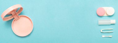 Kontak lens bakımı için aksesuarlı pankart. Kontak lensler için çözüm, kap, cımbız ve vakum kabı. Görme için hijyenik malzeme. Mesajın için yer aç. Uzayı kopyala Mavi arka plan. Uzun fotoğraf